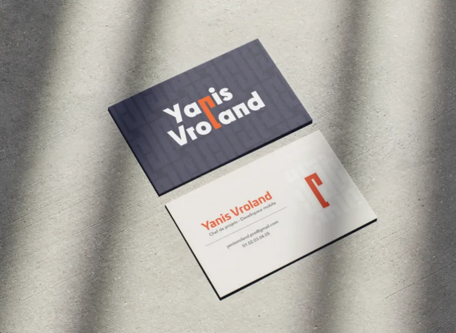 Cartes de visite Yanis Vroland, recto bleu nuit et verso blanc, sur fond de béton